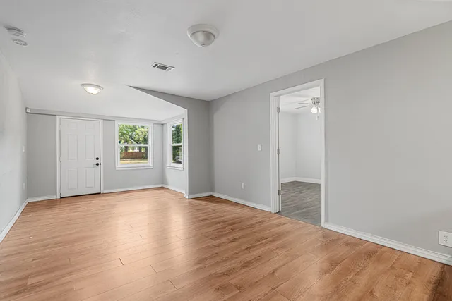 an empty room with windows and closet
