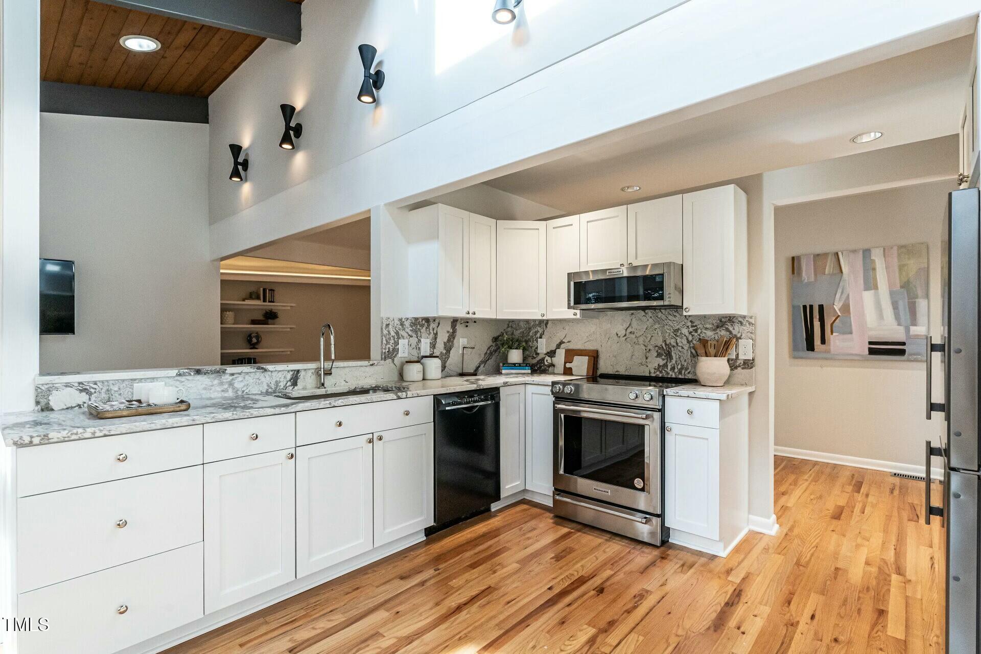 4824 Sandberry Lane Raleigh, NC 27613 - Photo 14 of 38 a kitchen with stainless steel appliances granite countertop a stove a sink and a microwave