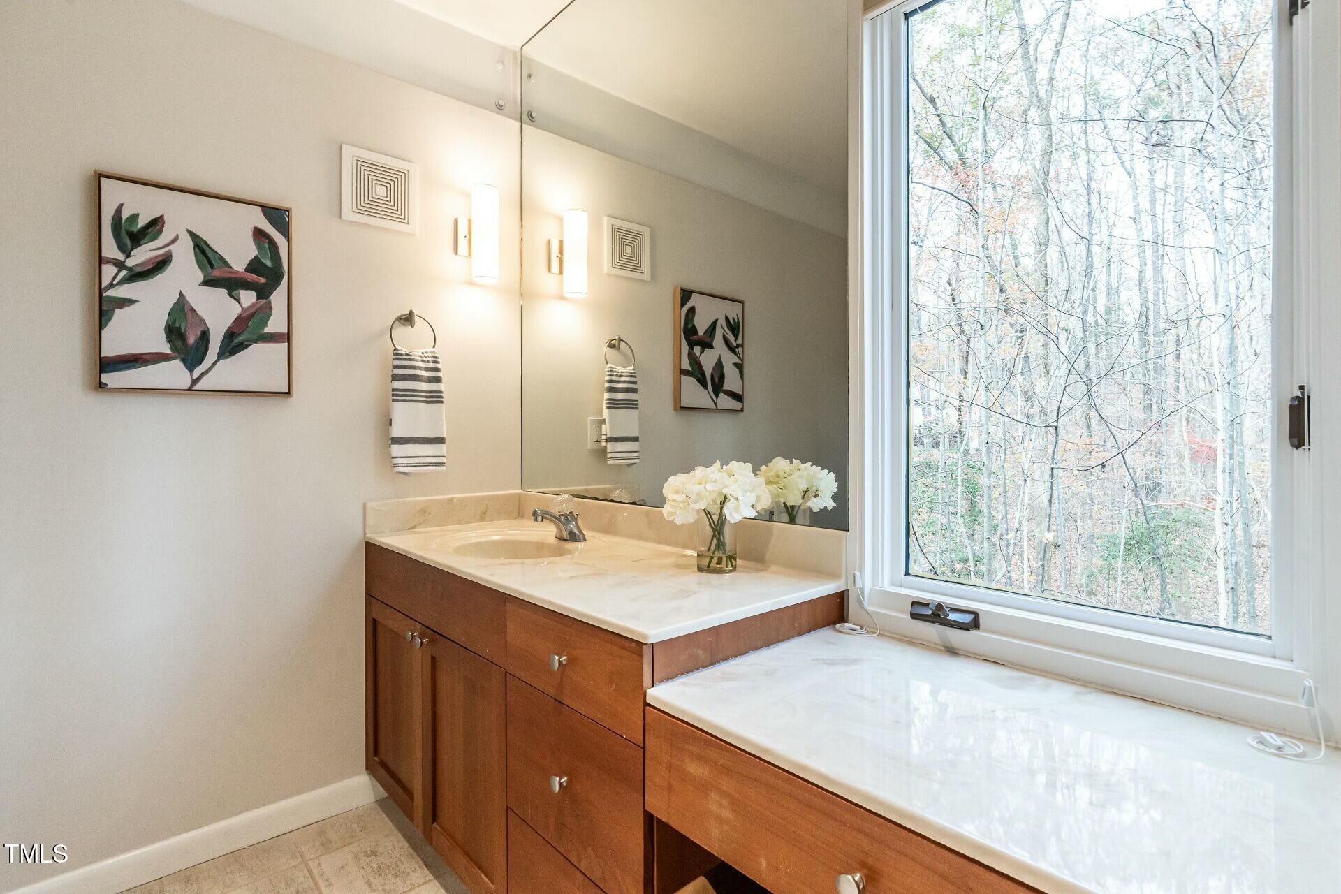 4824 Sandberry Lane Raleigh, NC 27613 - Photo 24 of 38 a bathroom with a sink and a mirror