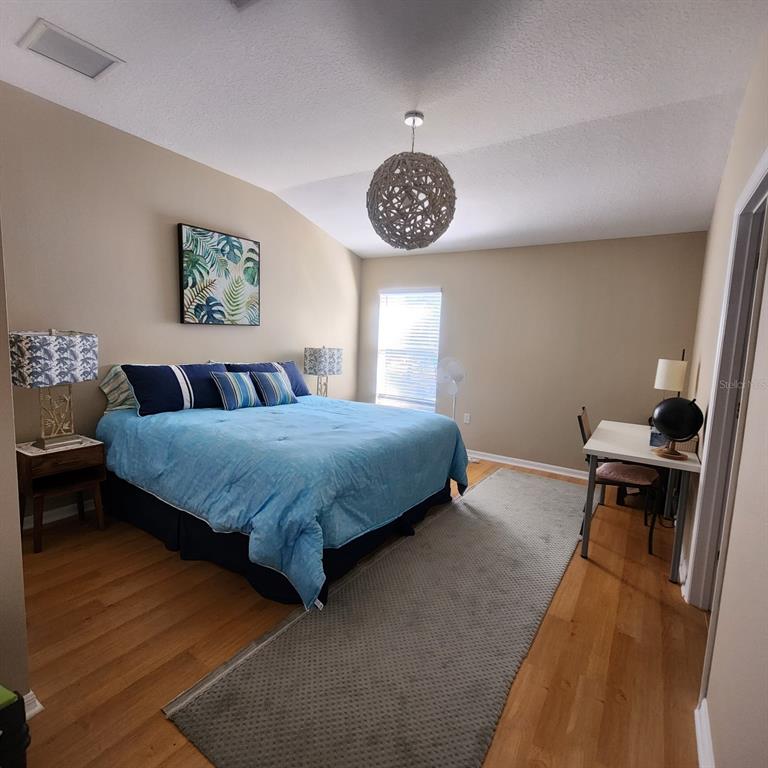 14982 Skip Jack Loop Lakewood Ranch, FL 34202 - Photo 12 of 28 a bedroom with a bed and a chandelier