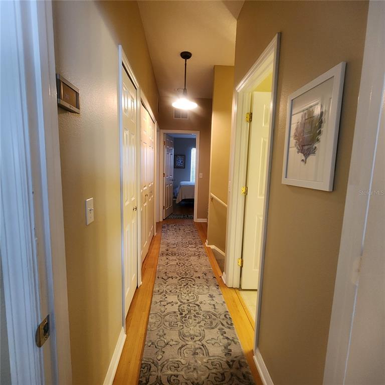 14982 Skip Jack Loop Lakewood Ranch, FL 34202 - Photo 18 of 28 a view of a hallway with wooden floor and staircase