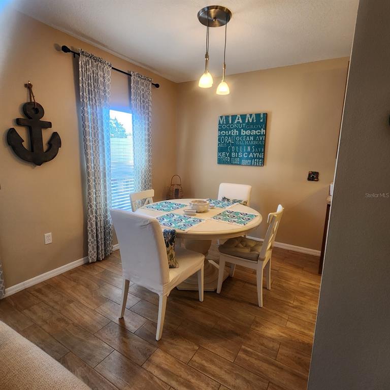 14982 Skip Jack Loop Lakewood Ranch, FL 34202 - Photo 5 of 28 a view of a dining room with furniture window and wooden floor