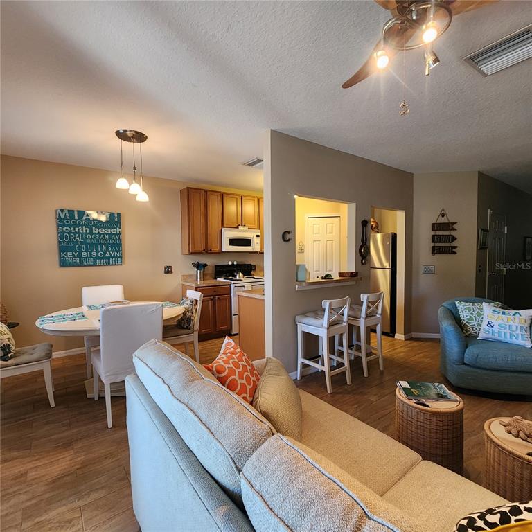 14982 Skip Jack Loop Lakewood Ranch, FL 34202 - Photo 8 of 28 a living room with furniture kitchen view and a large window