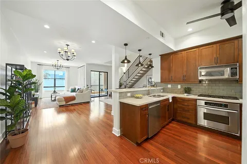a large kitchen with stainless steel appliances granite countertop a stove and a wooden floors