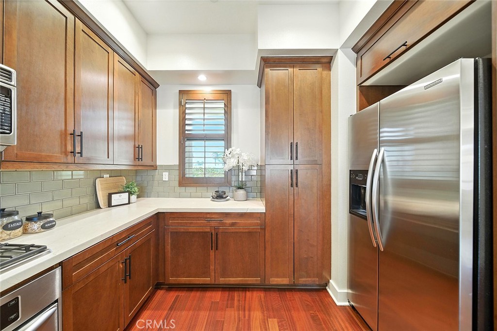 395 East 4th Street, Unit 39 Long Beach, CA 90802 - Photo 12 of 45 a kitchen with a sink a refrigerator and wooden cabinets