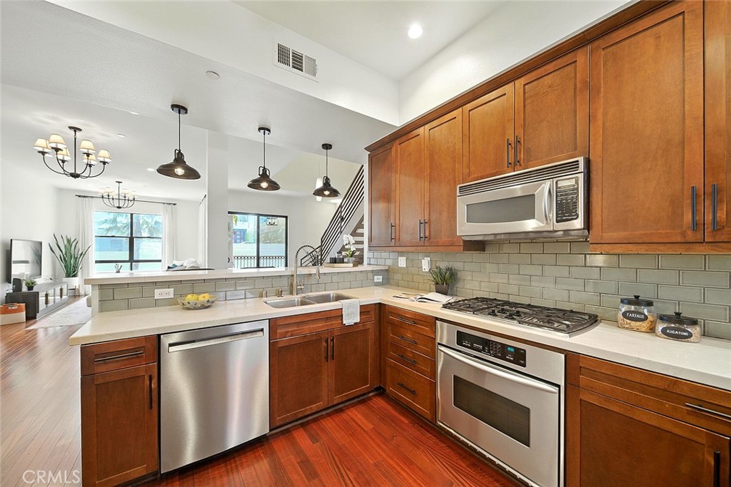 395 East 4th Street, Unit 39 Long Beach, CA 90802 - Photo 13 of 45 a kitchen with stainless steel appliances a sink stove and cabinets