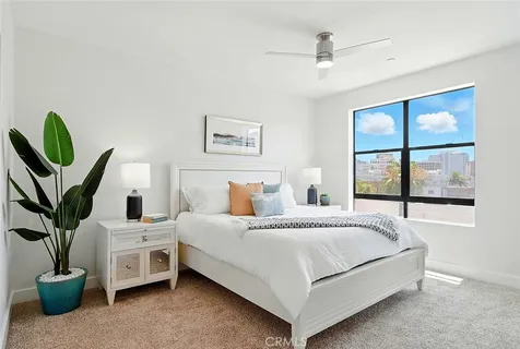 a bedroom with a bed and a large window