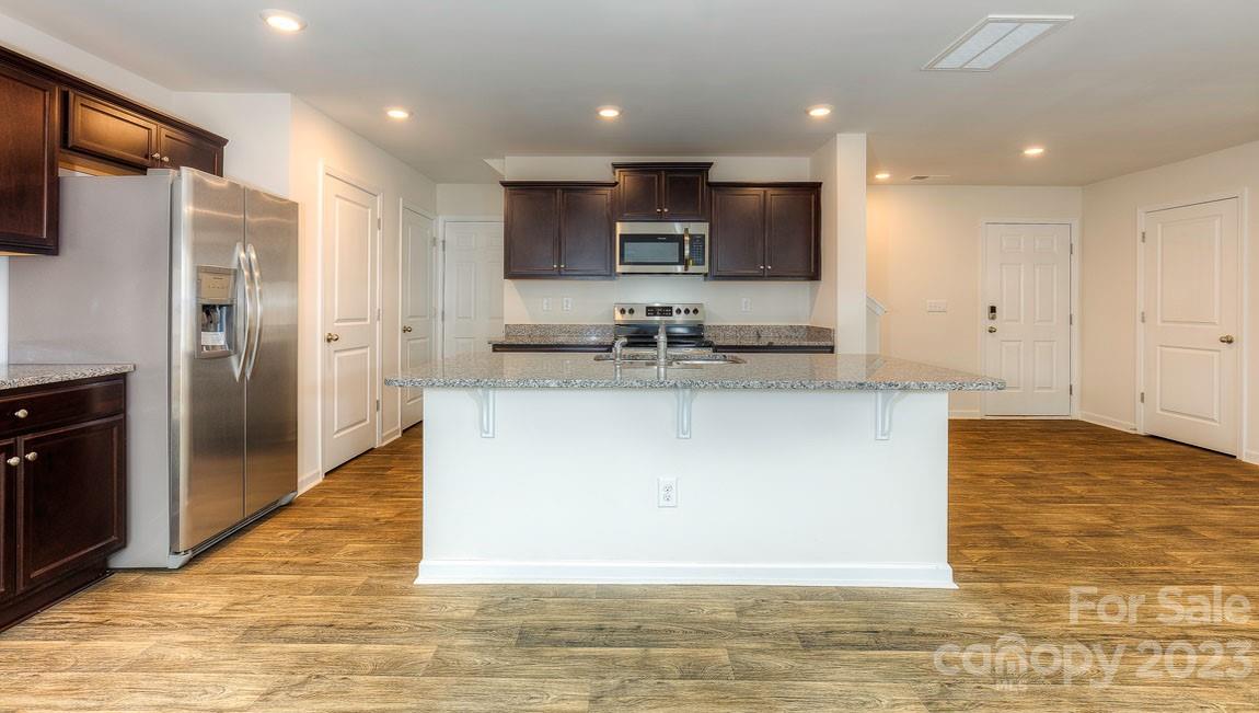 1603 Blue Velvet Lane Dallas, NC 28034 - Photo 3 of 17 a large kitchen with stainless steel appliances kitchen island granite countertop a refrigerator and a stove top oven