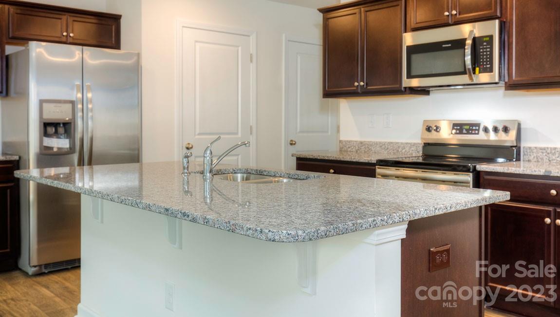 1603 Blue Velvet Lane Dallas, NC 28034 - Photo 4 of 17 a kitchen with stainless steel appliances granite countertop a sink a microwave and stove