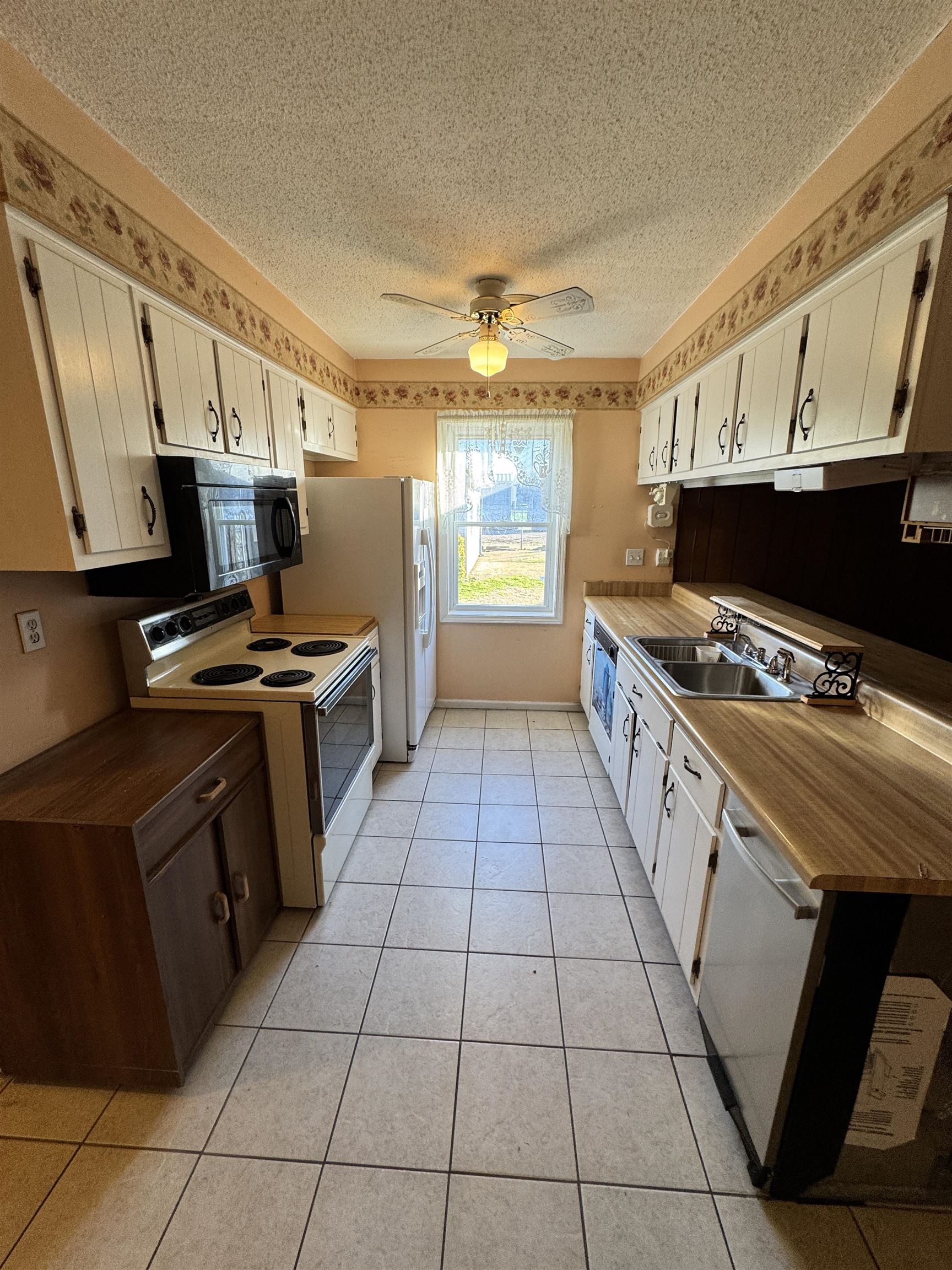 4777 Bill Knight Road Millington, TN 38053 - Photo 6 of 19 Kitchen with white appliances, white cabinets, a textured ceiling, ceiling fan, and light tile patterned floors