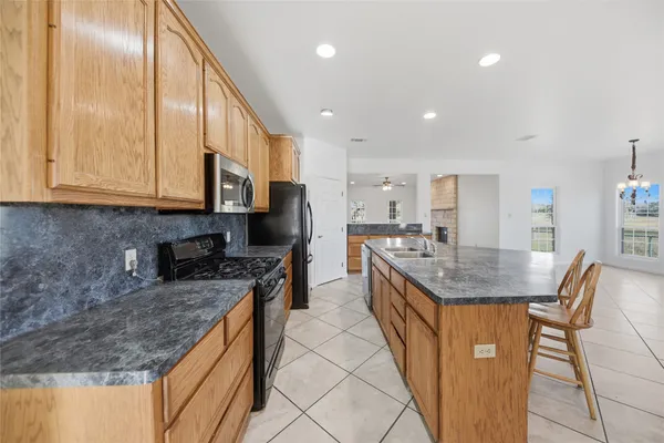 a kitchen with stainless steel appliances granite countertop a sink a stove and a refrigerator
