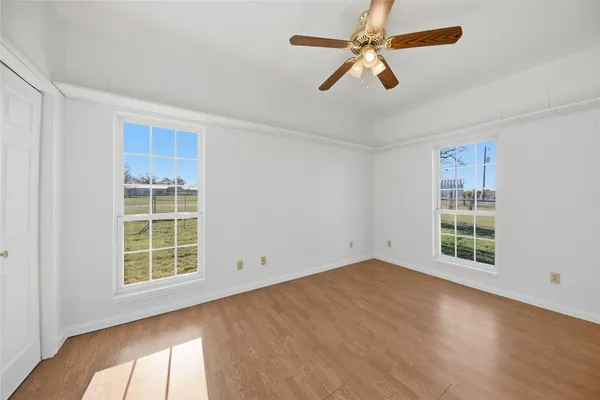 an empty room with windows and fan