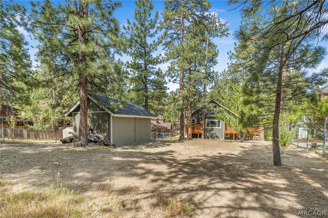 195 Elgin Road Big Bear Lake, CA 92315 - Photo 33 of 45 a backyard of a house with large trees and outdoor seating
