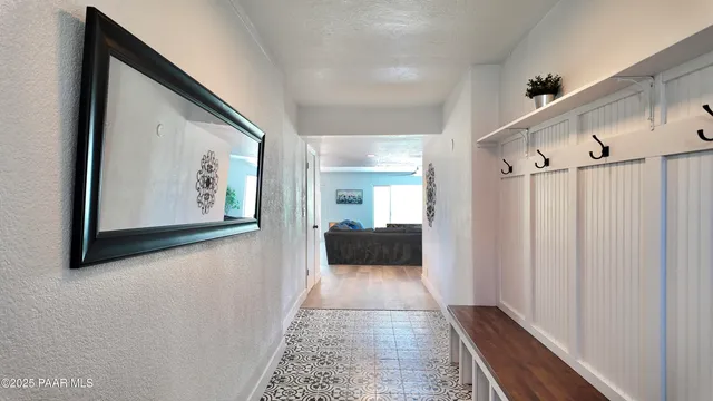 a view of a hallway with wooden floor and a bathroom
