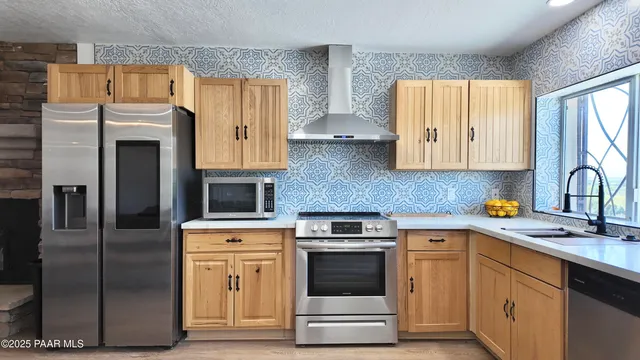 a kitchen with stainless steel appliances granite countertop a refrigerator and a stove