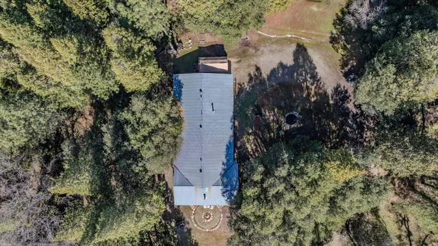 a front view of a house with yard and trees in the background
