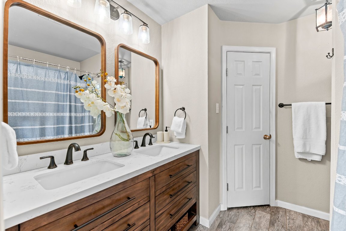 2201 Whistling Way Taylor, TX 76574 - Photo 30 of 40 a bathroom with a double vanity sink a mirror and a shower