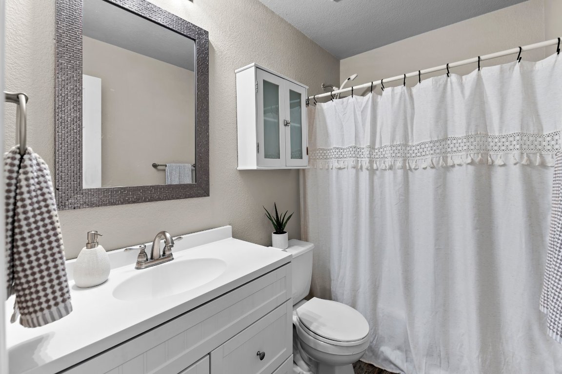 2201 Whistling Way Taylor, TX 76574 - Photo 8 of 40 a bathroom with a sink a toilet and shower curtain