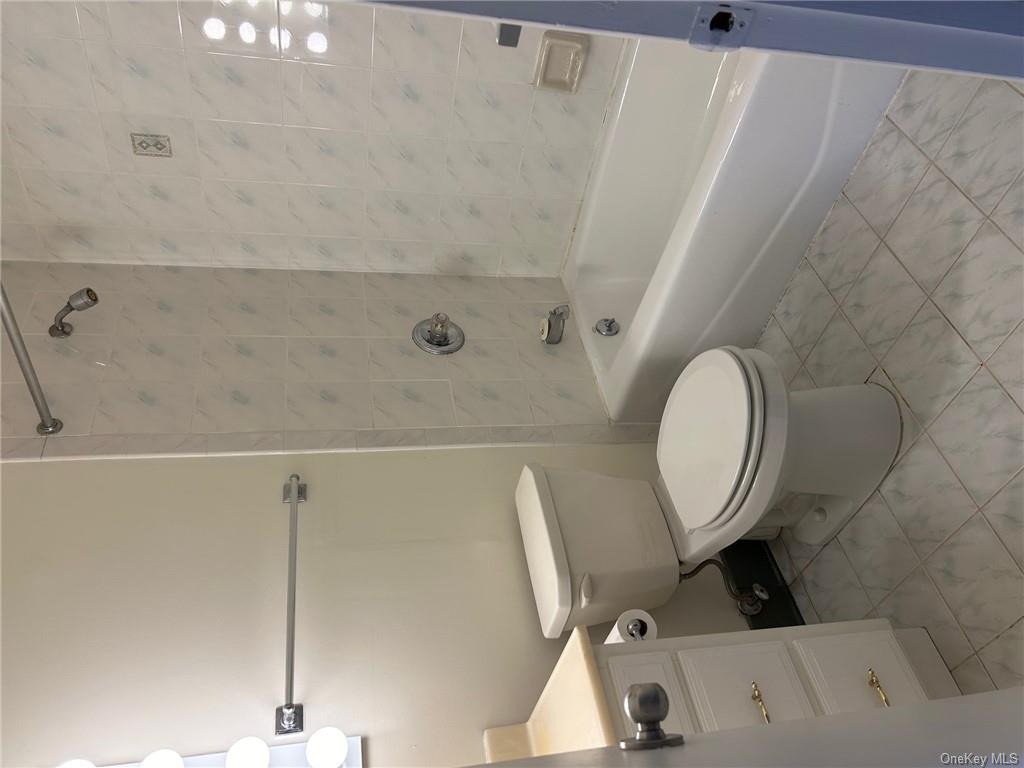 25 South Division Street Peekskill, NY 10566 - Photo 16 of 20 Full bathroom featuring tiled shower / bath, vanity, and toilet