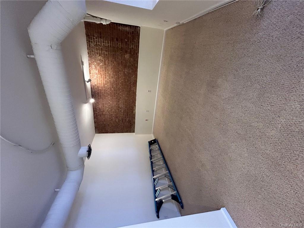 25 South Division Street Peekskill, NY 10566 - Photo 7 of 20 Basement with brick wall and carpet floors