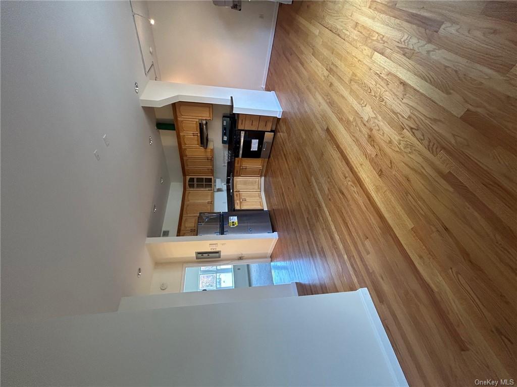 25 South Division Street Peekskill, NY 10566 - Photo 10 of 20 Open concept kitchen featuring fridge, light hardwood / wood-style flooring, ventilation hood, sink, and stove