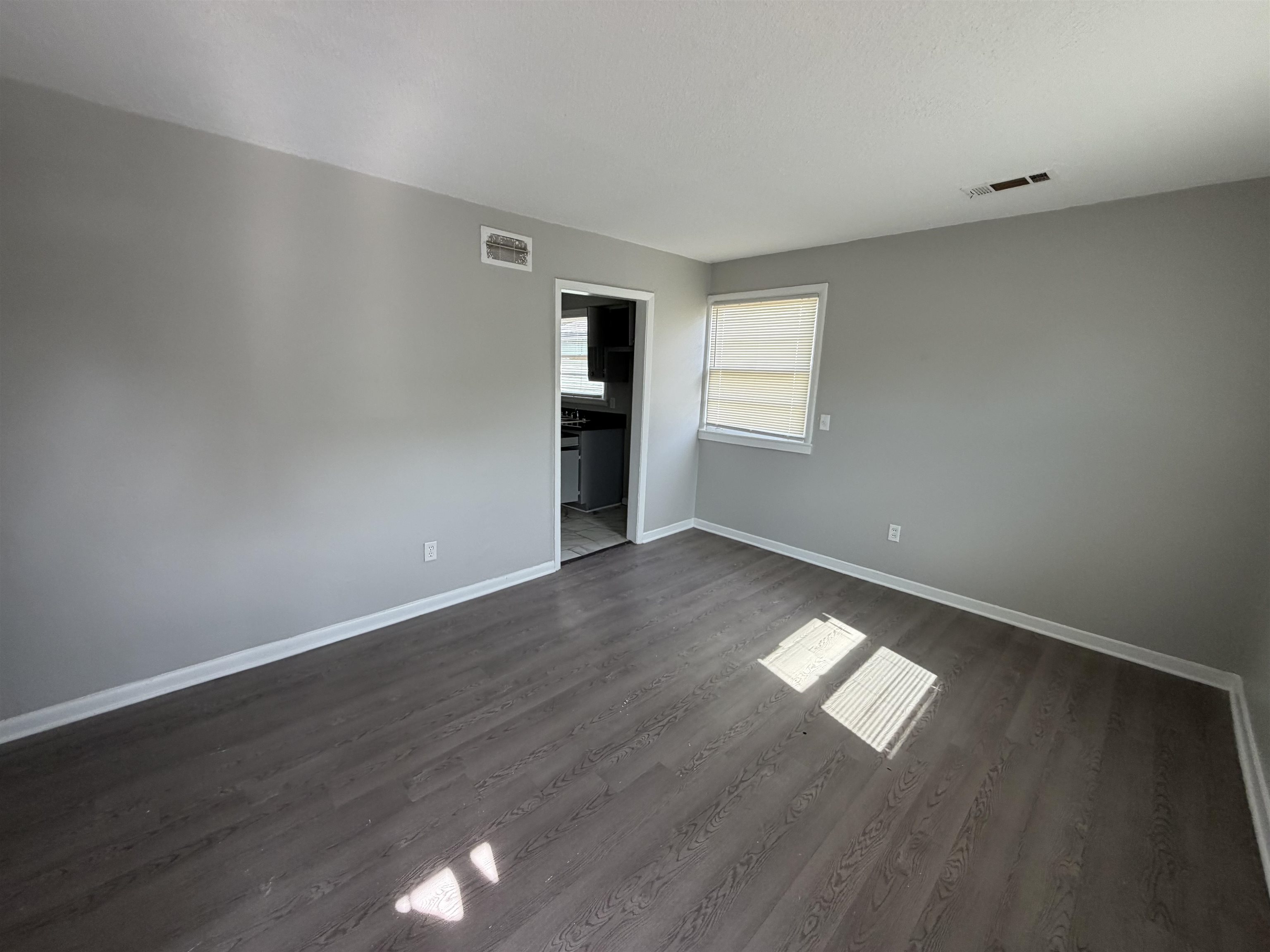 3525 Rochester Road Memphis, TN 38109 - Photo 3 of 10 Spacious room featuring neutral gray walls and wood-finish flooring