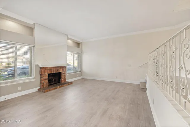 a view of an empty room with a fireplace and a window