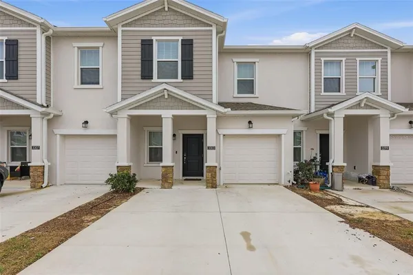 a front view of a house with yard and parking