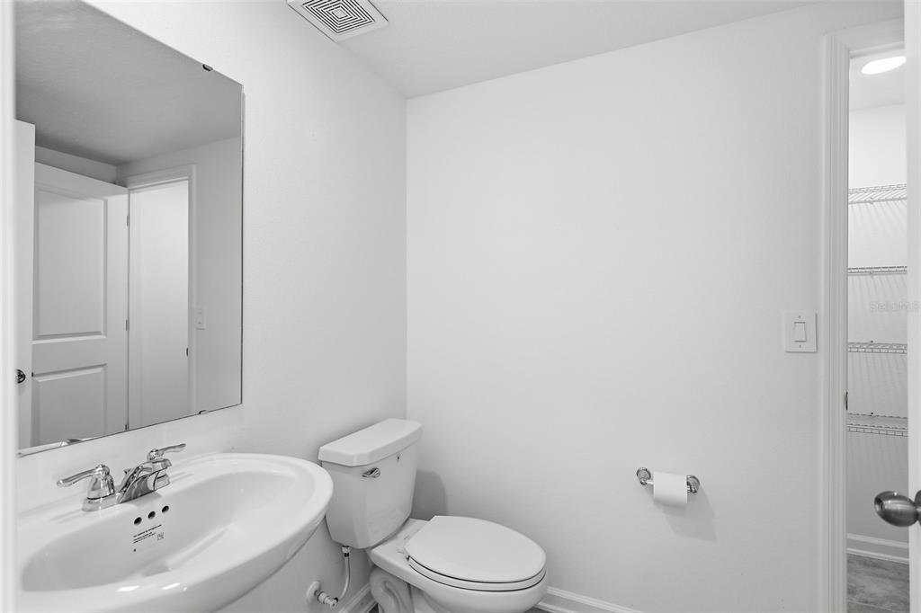3303 Laurent Loop Davenport, FL 33837 - Photo 17 of 37 a bathroom with a sink mirror and toilet