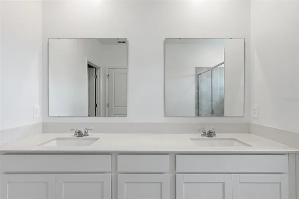 a bathroom with a shower sink and mirror