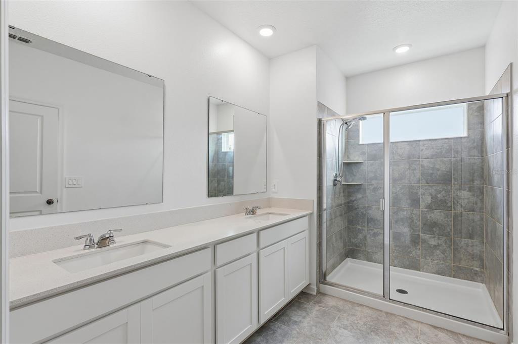 3303 Laurent Loop Davenport, FL 33837 - Photo 28 of 37 a bathroom with a shower sink and mirror