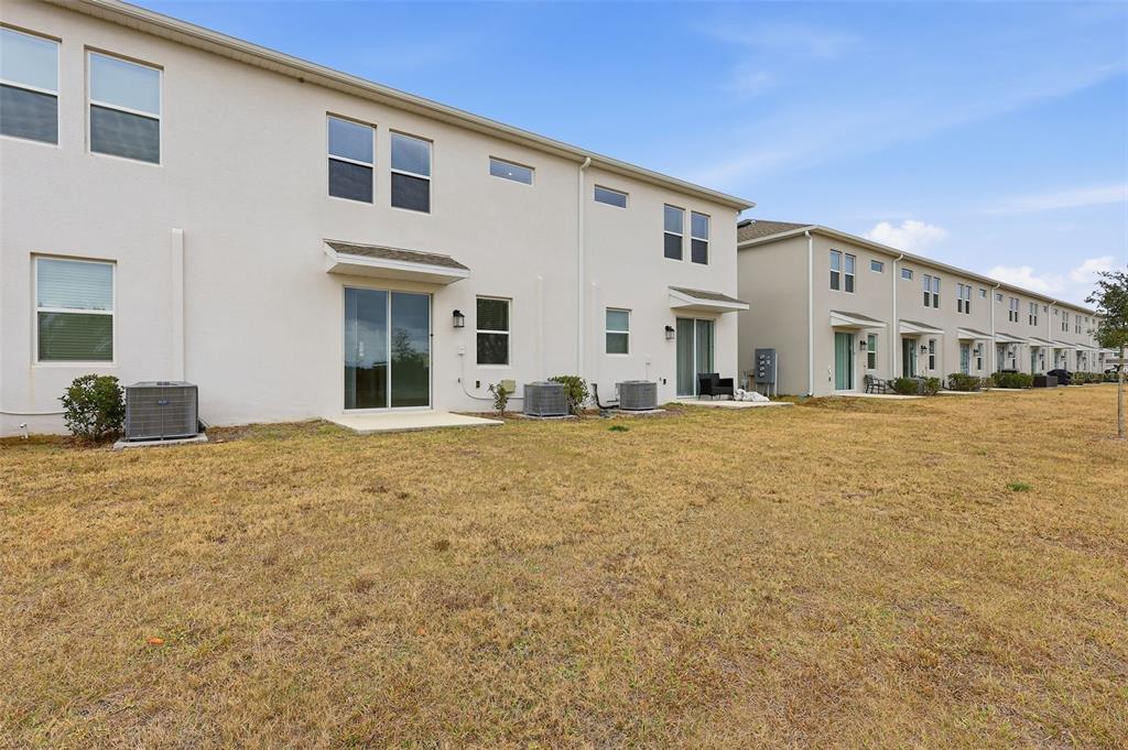 3303 Laurent Loop Davenport, FL 33837 - Photo 37 of 37 a large white building with a large parking space