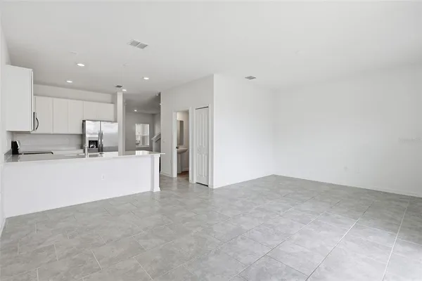 a view of kitchen with kitchen island white cabinets and refrigerator