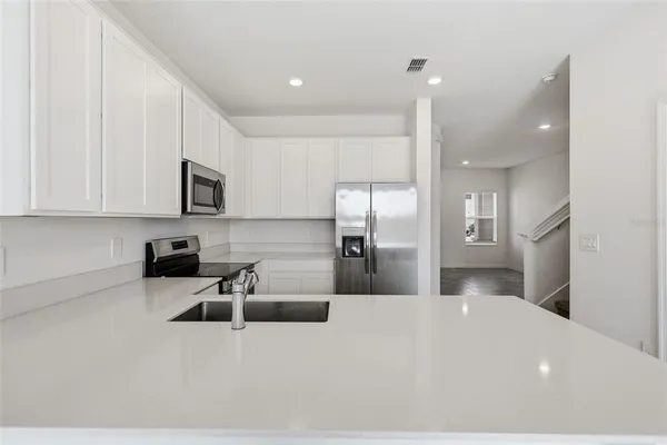 a kitchen with stainless steel appliances a microwave sink and refrigerator
