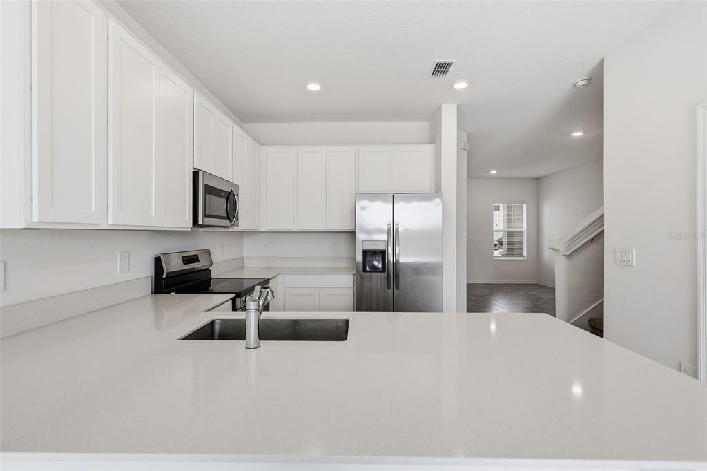3303 Laurent Loop Davenport, FL 33837 - Photo 10 of 37 a kitchen with stainless steel appliances a microwave sink and refrigerator