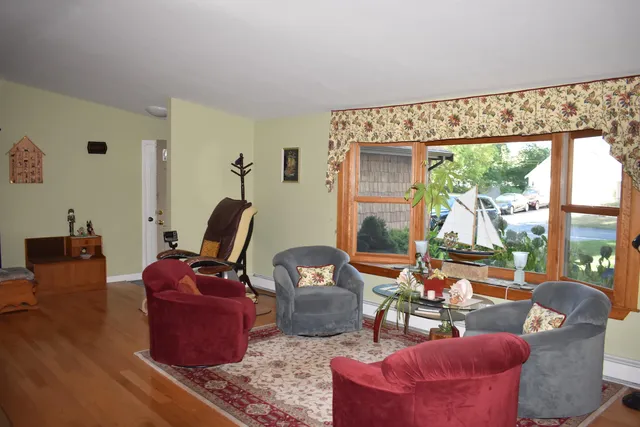 a living room with furniture a fireplace and a floor to ceiling window