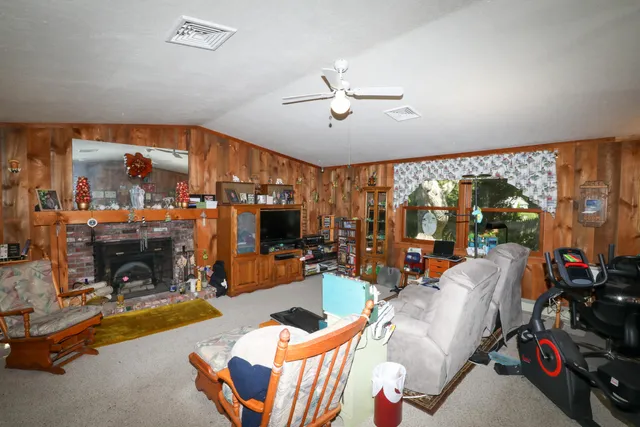 a living room with patio fireplace furniture and a large window