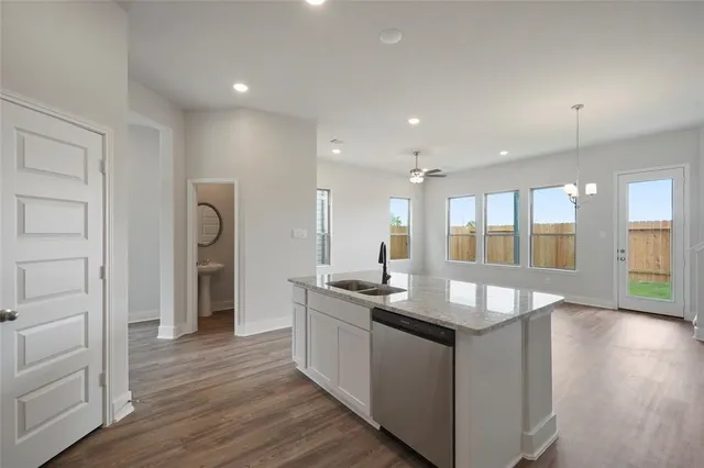 a kitchen with stainless steel appliances granite countertop a sink and a refrigerator