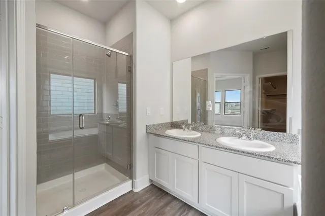 a bathroom with a granite countertop sink mirror and shower