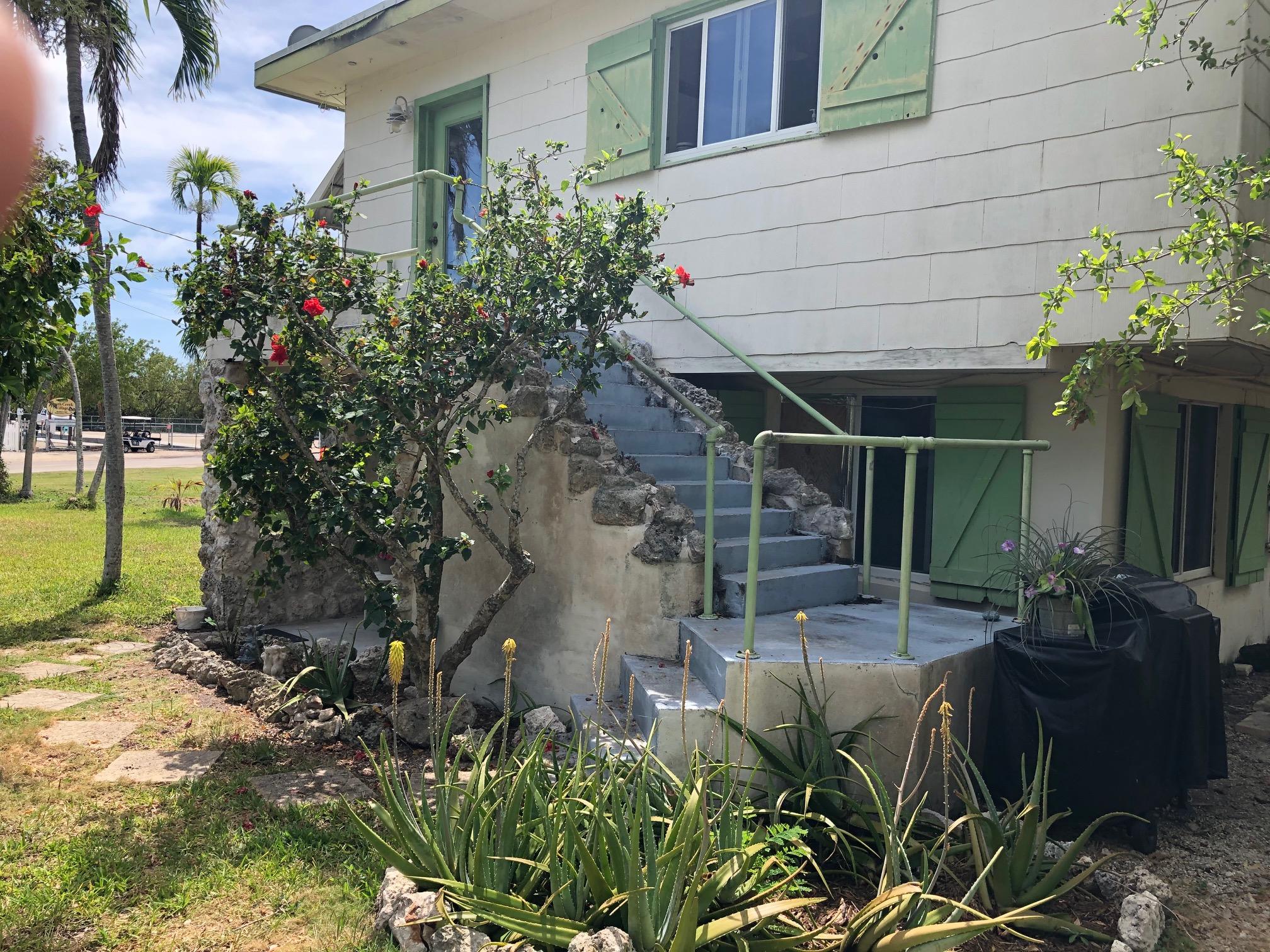 349 Sound Drive Key Largo, FL 33037 - Photo 4 of 16 a backyard of a house with table and chairs potted plants