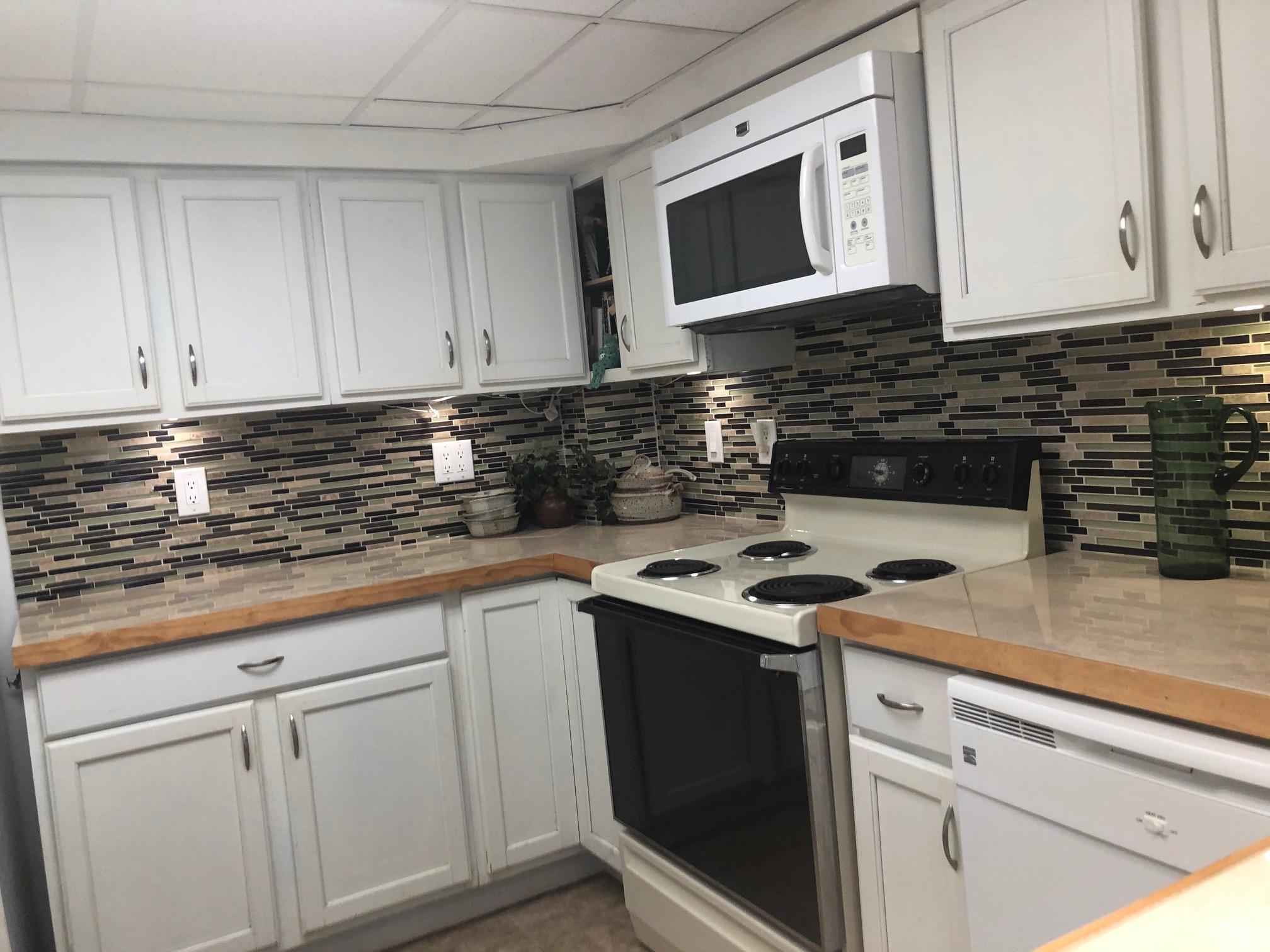 349 Sound Drive Key Largo, FL 33037 - Photo 8 of 16 a kitchen with stainless steel appliances granite countertop white cabinets stove a sink and dishwasher