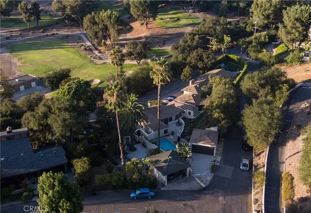 a view of swimming pool with lawn chairs and plants