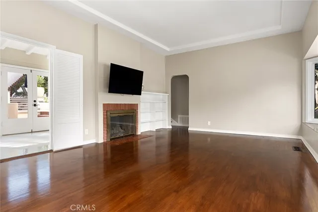 a view of a livingroom with wooden floor and a fireplace