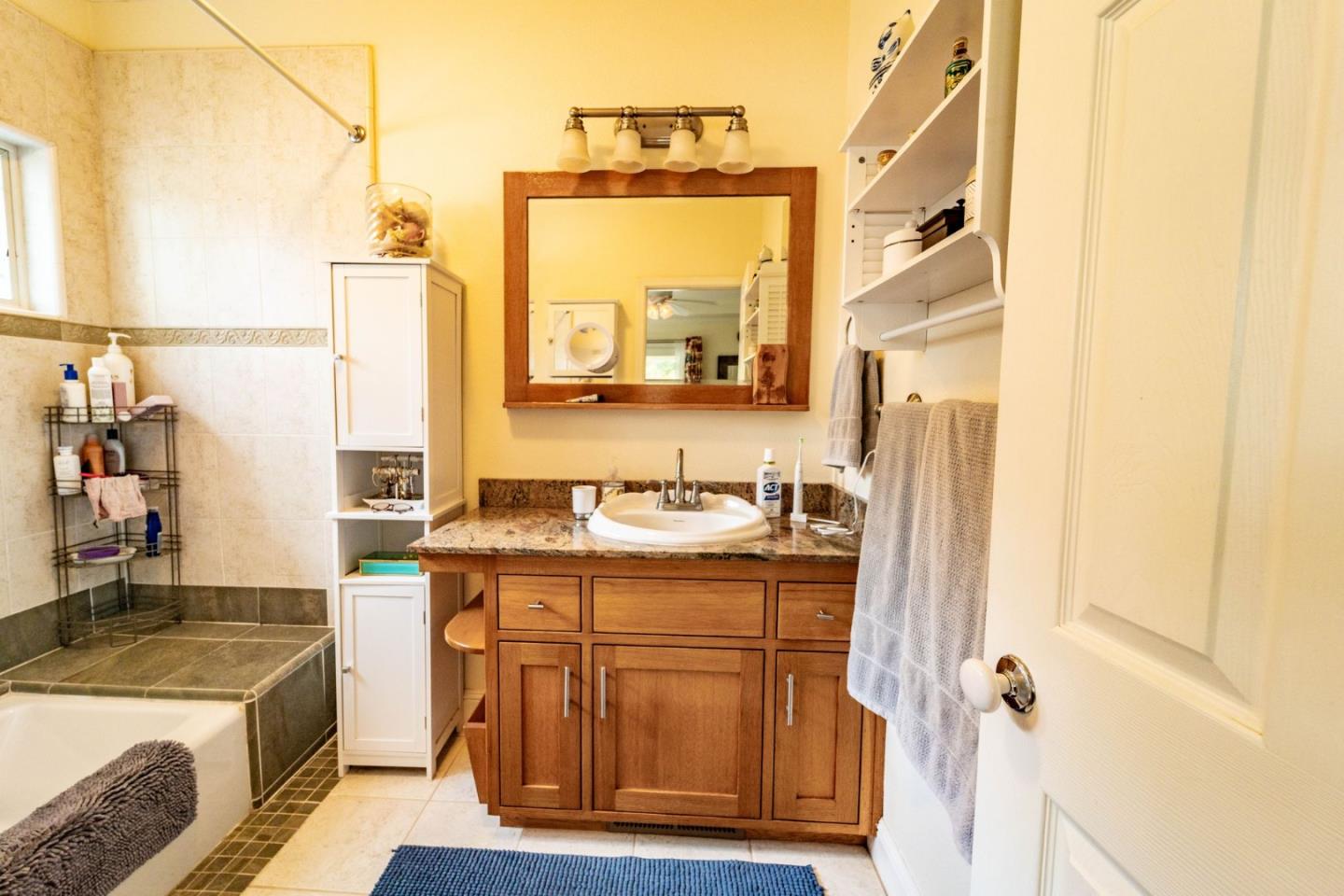 9110 Burchell Road Gilroy, CA 95020 - Photo 40 of 52 a bathroom with a granite countertop sink and a mirror