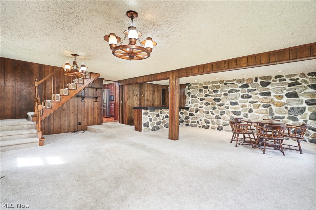 535 Crystal Lake Road Akron, OH 44333 - Photo 16 of 40 Family Room with bar, custom built stone wall and rear stairs to second floor bonus room and bedrooms.