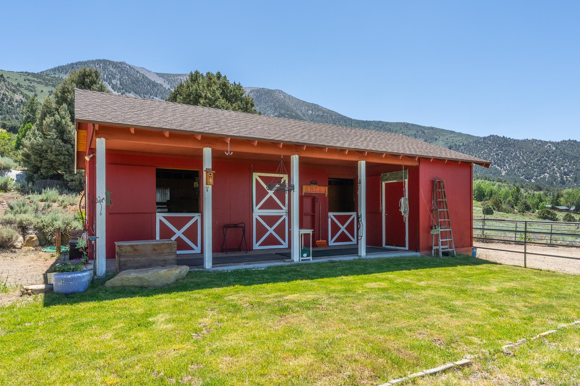 537 Aspen Spring Ranch Road Mammoth Lakes, CA 93546 - Photo 28 of 40 Red stable structure featuring three stalls with Dutch doors and a covered porch