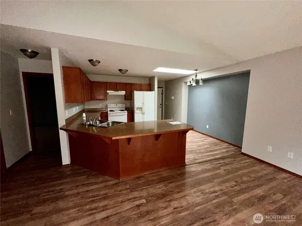 a kitchen with stainless steel appliances granite countertop a refrigerator and a stove