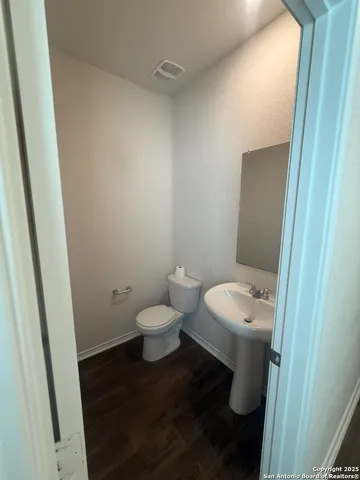 a view of a kitchen with kitchen island white cabinets and wooden floor