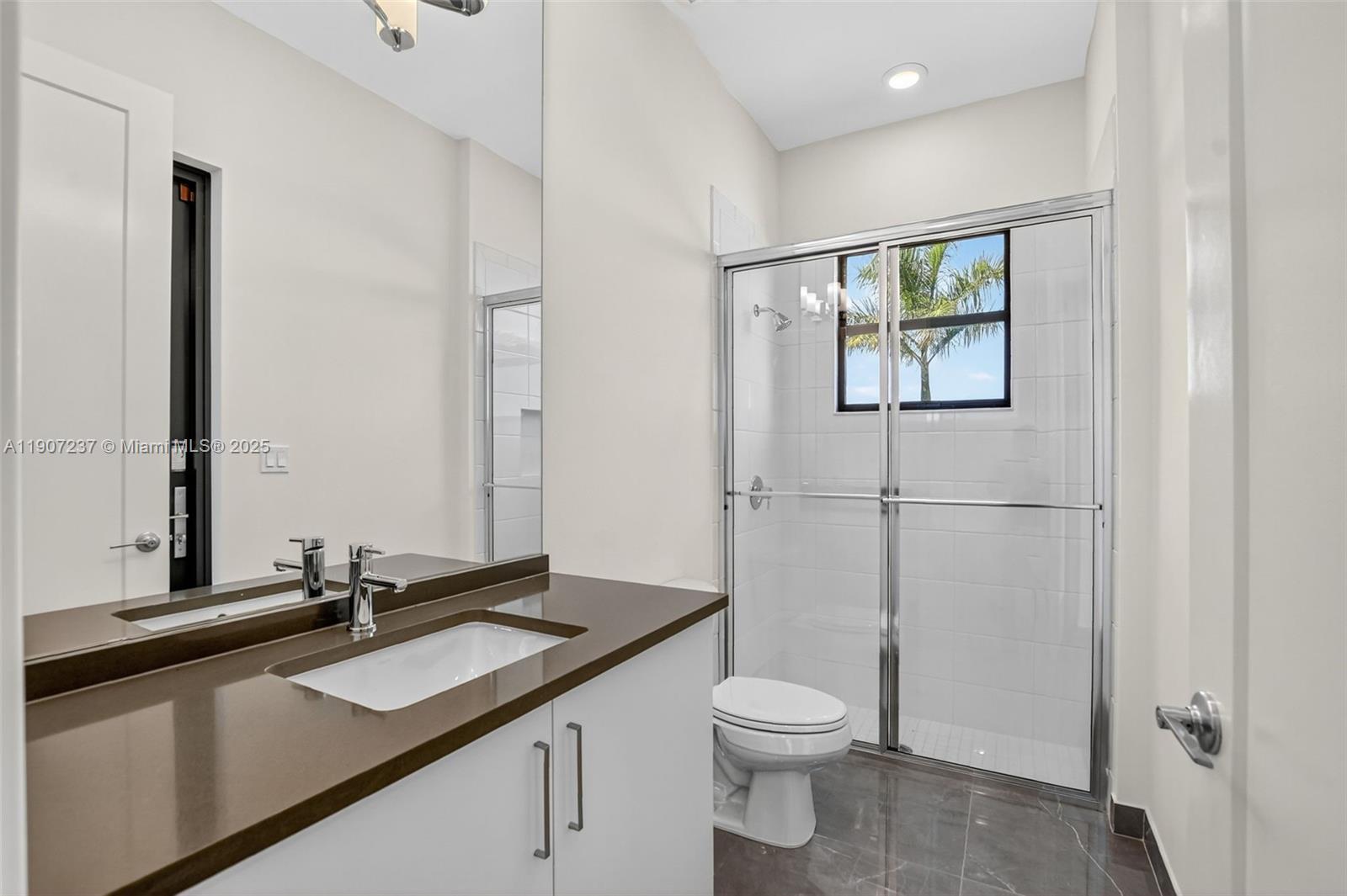 8215 Crystal Downs Avenue, Unit 8215 Boca Raton, FL 33434 - Photo 28 of 95 a bathroom with a toilet sink and mirror