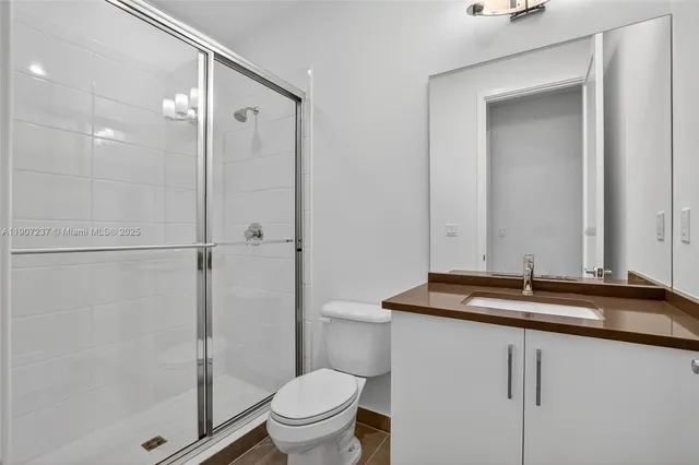 a front view of a house with a garden and palm trees